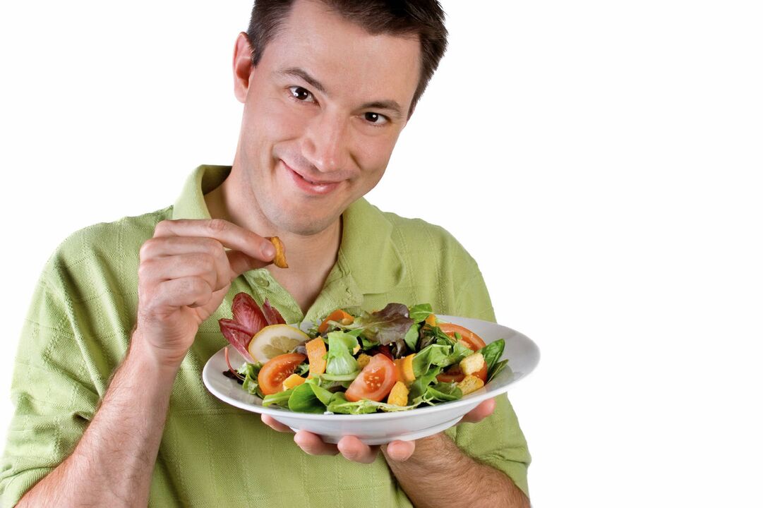 человек ест овощной салат, чтобы накачать